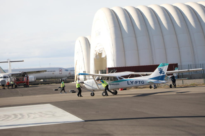 Una avioneta per a formació de pilots i, al fons, hangars inflables i avions aparcats a Alguaire.