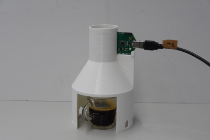 La taza de café y, arriba, el circuito electrónico del eNose.