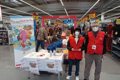 Dos voluntarios de Creu Roja, en uno de los puntos de recogida de juguetes solidarios. 