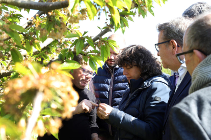 La consellera Teresa Jordà i el president de la Diputació, Joan Talarn, observen les flors cremades.