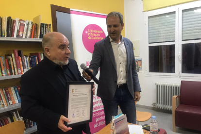 Ferran Sáez con el acuerdo para poner su nombre a la biblioteca y Manel Solé, ayer en el acto. 