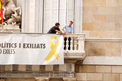 Dos trabajadores empiezan a sacar la pancarta de los presos del Palau de la Generalitat en el 2019.