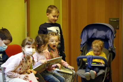 Infants arribats d'Ucraïna fugint de la guerra mirant contes a la biblioteca de Guissona