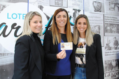 Marta Barcala, junto con sus dos compañeras de trabajo, exhibiendo el número. 