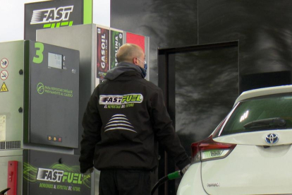 Un home carrega de gasolina el dipòsit d’un vehicle.