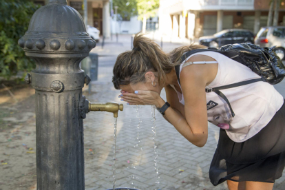 Una dona es refresca en una font a Lleida per la calor en una imatge d'arxiu.