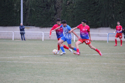 Un jugador del Artesa de Lleida, perseguido por dos del Torrefarrera.