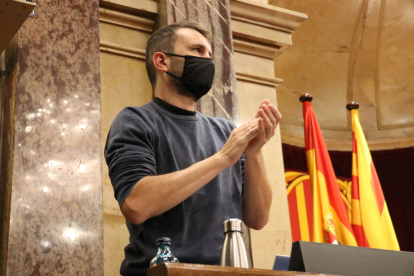 El secretario tercero de la Mesa, Pau Juvillà (CUP), devuelve el aplauso al hemiciclo en el inicio del pleno del Parlament del 14 de diciembre.