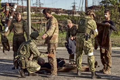 Soldats russos escorcollen militars ucraïnesos, després de sortir de l’acereria d’Azovstal, a Mariúpol.