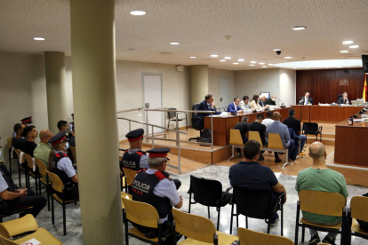 Los once acusados de tráfico de drogas, en la Audiencia de Lleida, durante el juicio en el que se ha llegado a una conformidad. Algunos de los acusados han tenido que sentarse al final de la sala, a la izquierda.