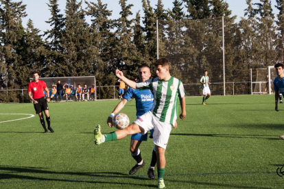 Un jugador de l’Alguaire mira de controlar la pilota davant la pressió d’un rival.