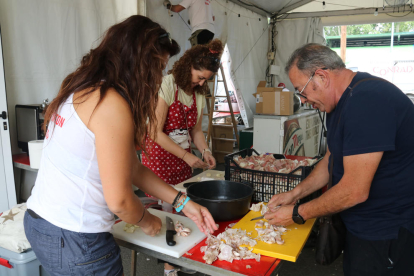 Los miembros de un grupo del Aplec del Caragol de Lleida preparan la comida.