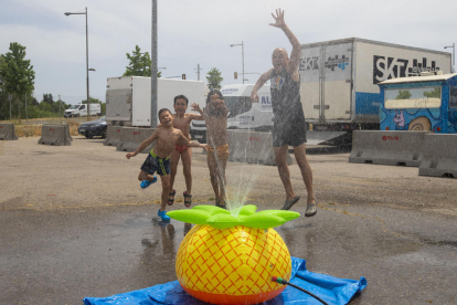 Niños y un adulto remojándose ayer en la ciudad de Lleida, donde se alcanzaron los 33 grados. 