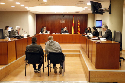 El hombre (de negro), acusado de violar a la mujer y abusar de la hija, en la Audiencia de Lleida, acompañado de un traductor (de gris).