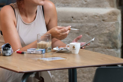 Una mujer fumando en una terraza