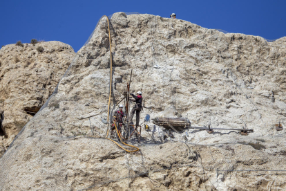 Els operaris treballen verticalment a la instal·lació dels ancoratges a la roca per fixar el pendent.