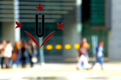 Un vidre amb el logotip de la Universitat de Lleida (UdL) i estudiants caminant al fons