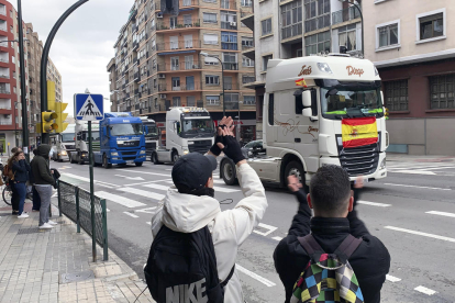 Varias personas saludan con signos de apoyo a los pequeños transportistas se manifestaron ayer por las calles de Zaragoza.