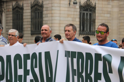 Campesinos de Lleida levantando una pancarta durante la protesta en la plaza de Sant Jaume