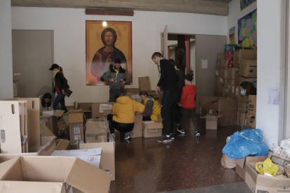 Diversos voluntaris preparant caixes amb material de primera necessitat per enviar de Barcelona a Ucraïna.