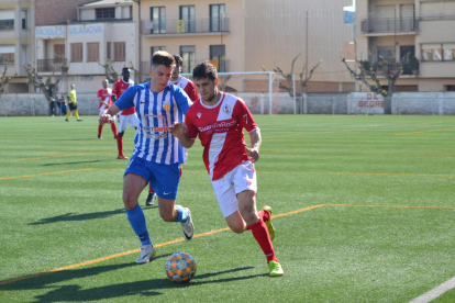 Un jugador del Artesa de Segre pugna por el balón con otro del Artesa de Lleida.