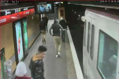 Imatge extreta del vídeo de seguretat on es veuen cinc joves seguint la víctima abans d'agredir-la al peu de l'andana del Metro.
