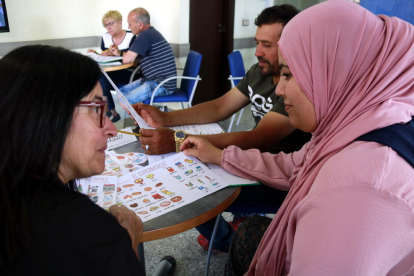 Una voluntària de l'entitat Lo Portal de Sudanell ensenya català a Houria Laghlid, veïna que va demanar fer classes de català al municipi