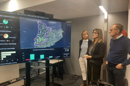 Una dona consulta el missatge de Protecció Civil a la terrassa d’un bar a la Pobla de Segur.