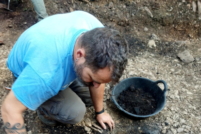 Un arqueòleg excavant un dels fornals del jaciment.
