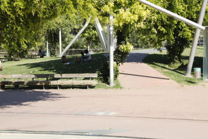 Dos jóvenes se refugian del sol bajo un árbol ayer en un parque de Lleida, que llegó a los 34ºC.