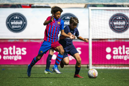 Un jugador del Barça i un de l’Atlètic Lleida pugnen per una pilota en l’edició de l’any passat.