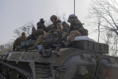 Militars ucraïnesos a sobre d’un vehicle blindat en una carretera a Bakhmut.