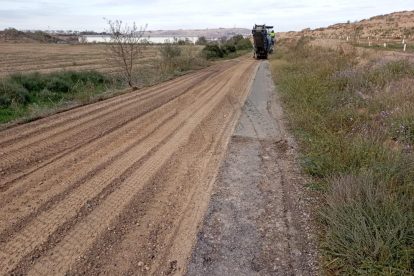 Treballs per convertir en camí de terra un tram de la carretera de Castelldans a Cervià (esquerra) i imatge del mal estat que presenta la calçada.