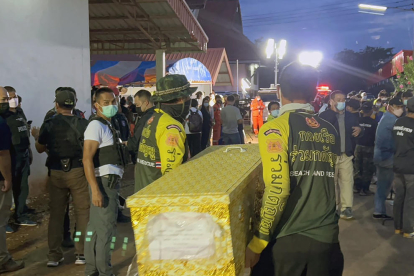 Treballadors de rescat carreguen un taüt que conté una víctima de la massacre.