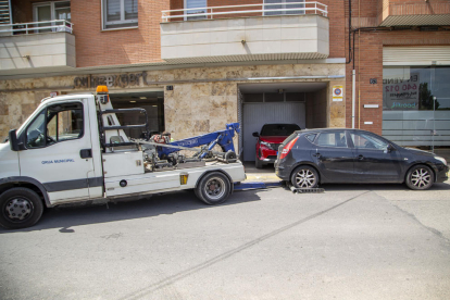 Una grúa retira un vehículo estacionado en un vado en Lleida. 