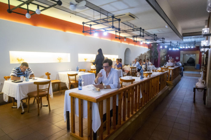 Un hombre come justo debajo de un ventilador que ha colocado el restaurante La Masía, ayer. 