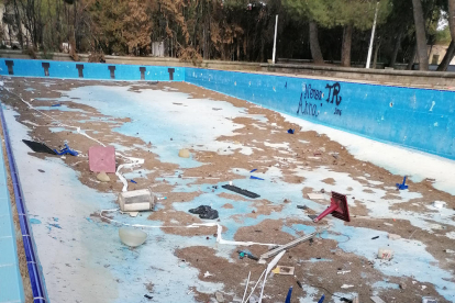 Restos de vegetación seca y desperdicios en la piscina infantil.