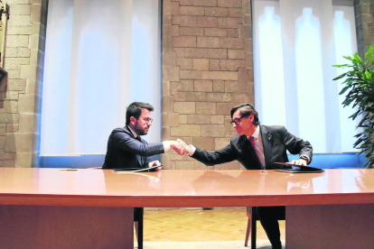 Aragonès e Illa se estrechan la mano tras firmar el pacto.