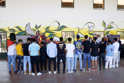 Joves del centre de justícia juvenil El Segre de Lleida davant del mural que han pintat