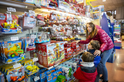 Una família mirant ahir joguets de la pel·lícula 'Cars' a la botiga Agustí Mestre