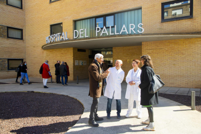 Manel Balcells y Tània Verge conversando con sanitarios en el exterior del hospital de Tremp.