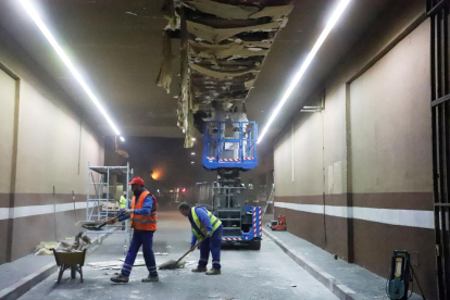 Operaris treballant ahir a la nit en la reparació del fals sostre de l’entrada.