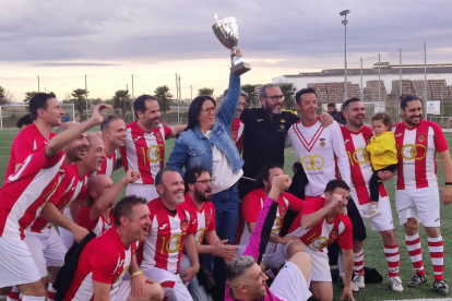 La presidenta del club levanta la Copa lograda por los Veteranos.