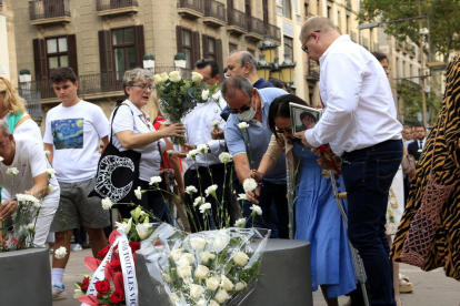 La familia del niño australiano que murió en los atentados del 17-A y otros familiares depositan los claveles blancos en recuerdo de las víctimas, en la conmemoración de los cinco años, en el memorial