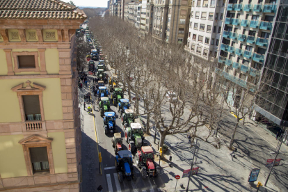 A peu rere una pancarta. Els manifestants van deixar els tractors a l’avinguda Prat de la Riba i van marxar a peu rere una pancarta cap a les oficines d’Acció Climàtica a Lleida.