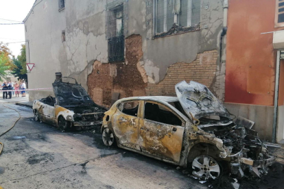Els dos cotxes estacionats al carrer Zulueta de Torregrossa, calcinats ahir al matí.