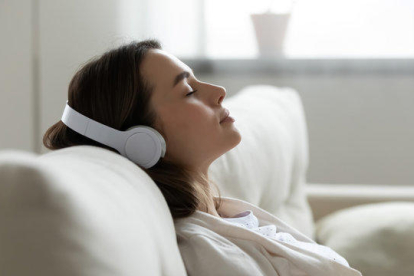 Una dona dormint mentre escolta música amb auriculars.