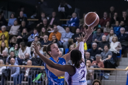 Laura Peña busca una compañera a la que pasar el balón ante Andela Delic.