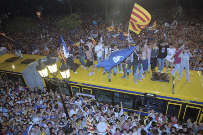 L’autobús que va portar la plantilla blava fins a la Paeria, envoltat d’aficionats en una celebració per a la història.