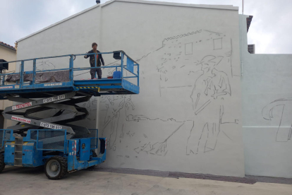 Oriol Arumí, vora el mural que va començar a pintar ahir a la placeta Mossèn Amadeu de Torrelameu